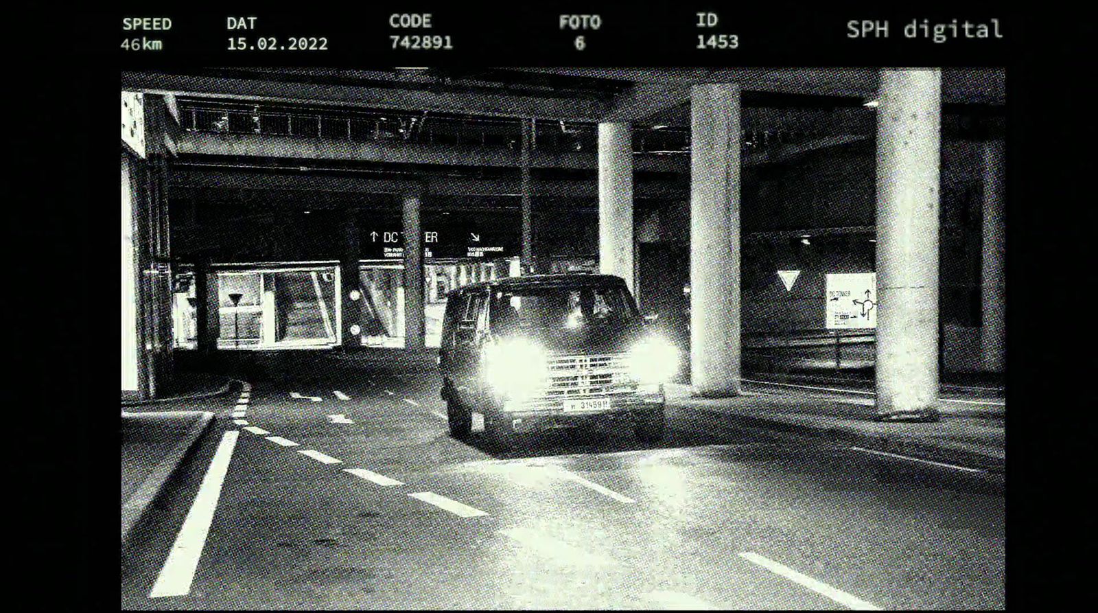 a black and white photo of a car in a parking garage