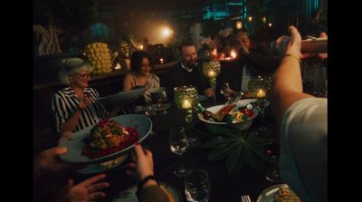 a group of people sitting around a table with plates of food