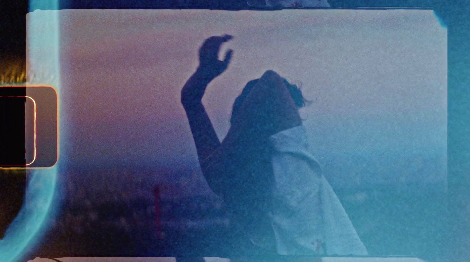 a woman standing in front of a window with her hand up