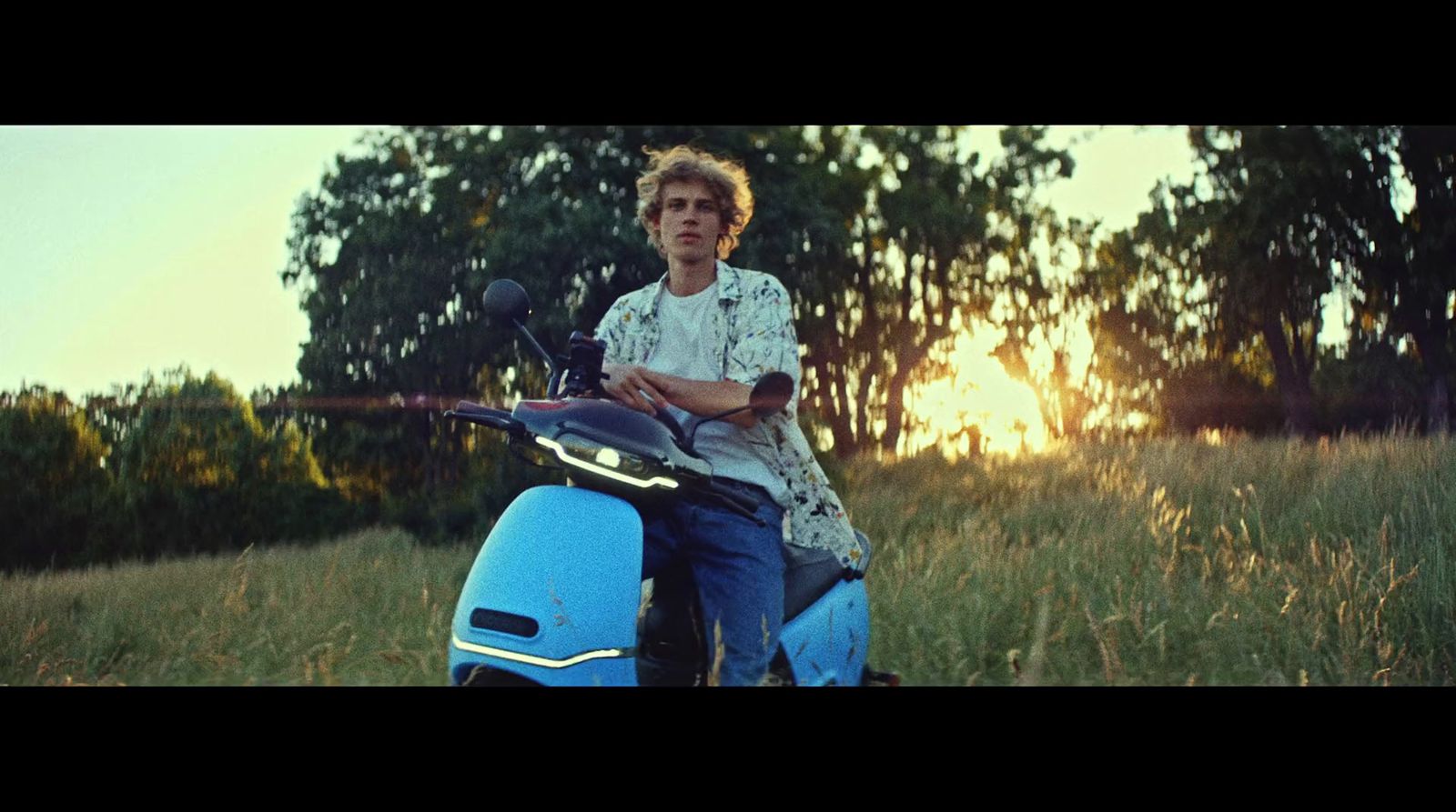 a man sitting on a scooter in a field