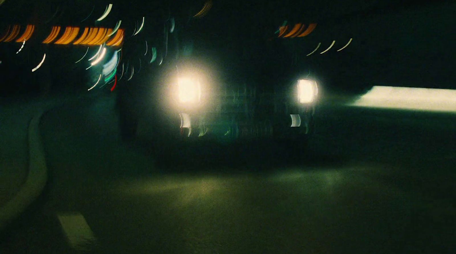 a car driving down a street at night