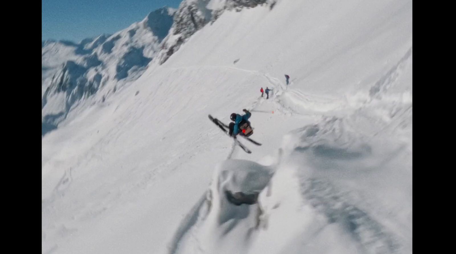 a group of people riding skis down a snow covered slope