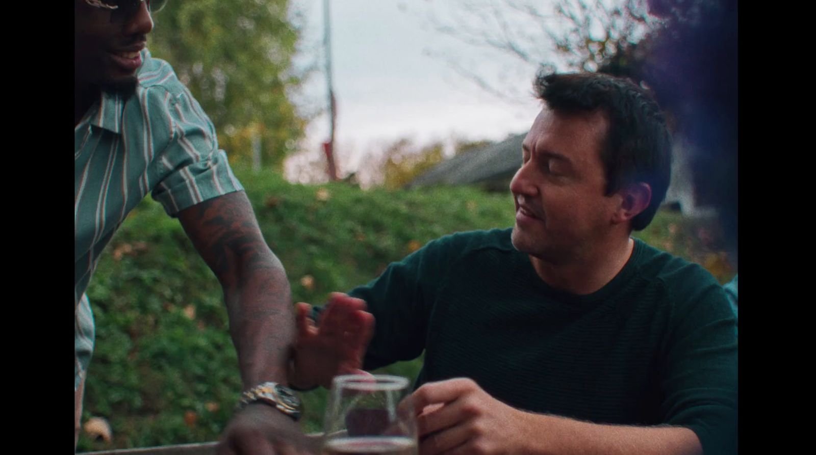 two men sitting at a table talking to each other