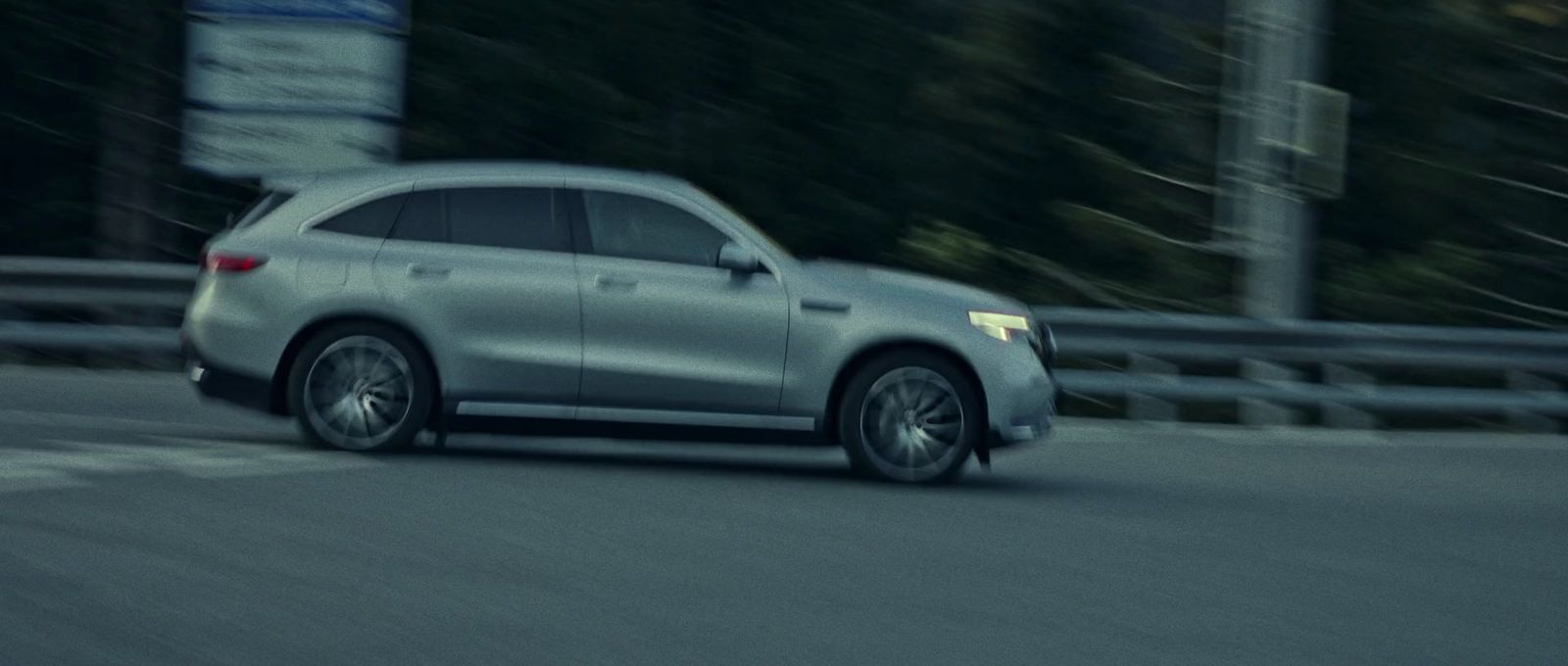 a silver mercedes suv driving down a street