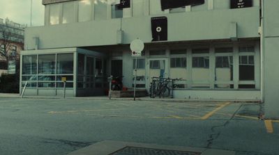 an empty parking lot with a building in the background