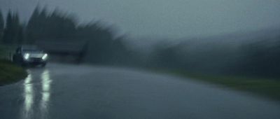 a car driving down a wet road in the rain