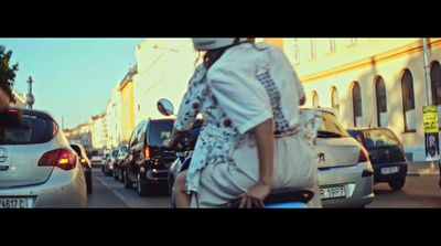 a woman riding a scooter down a busy street