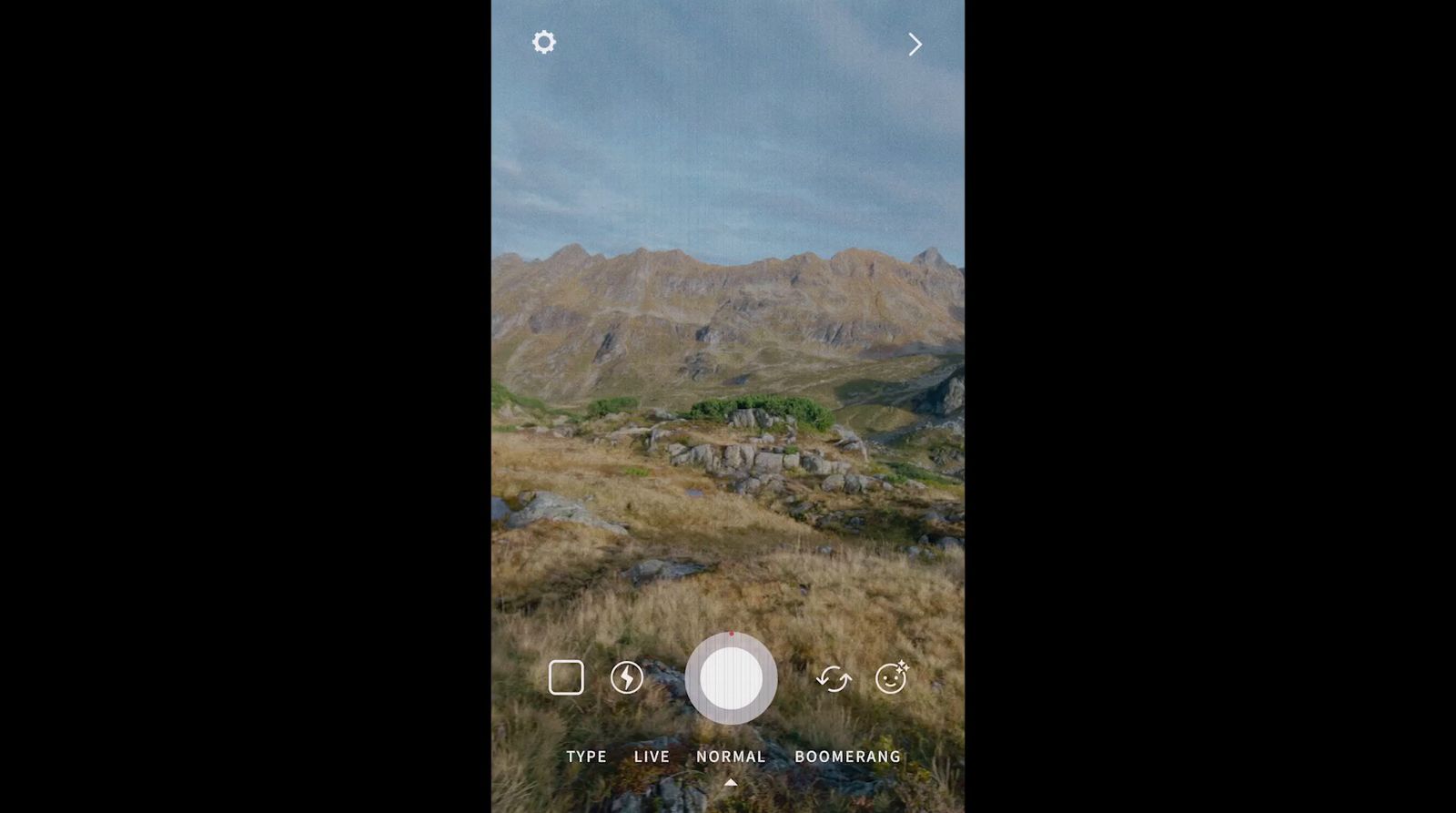 a cell phone with a picture of a mountain in the background