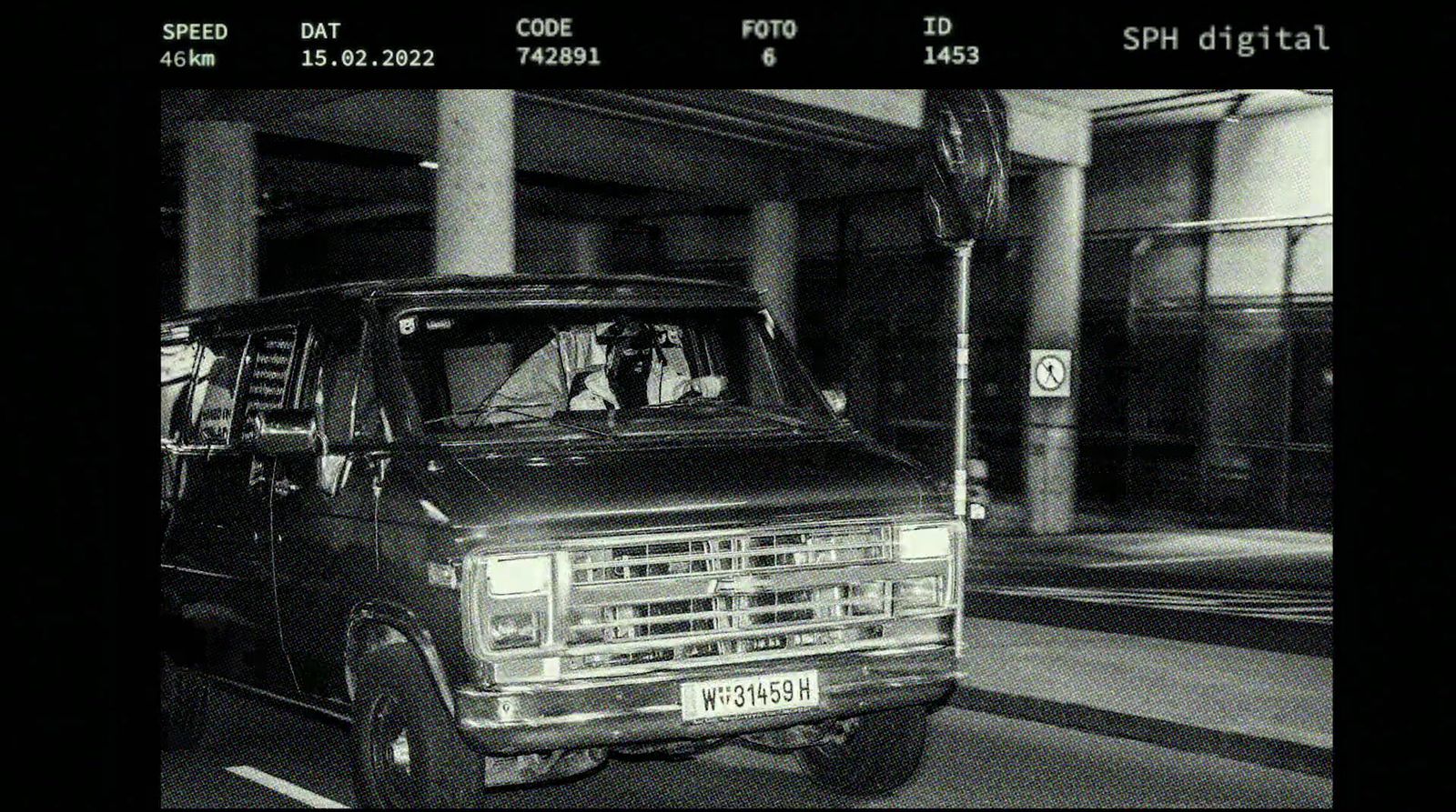 a black and white photo of a truck driving down a street