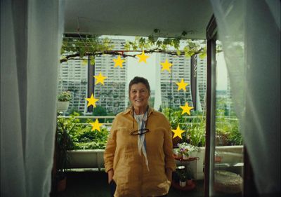 a woman standing in front of a window with yellow stars on it