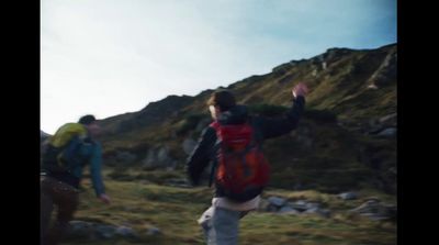 a group of people standing on top of a lush green hillside