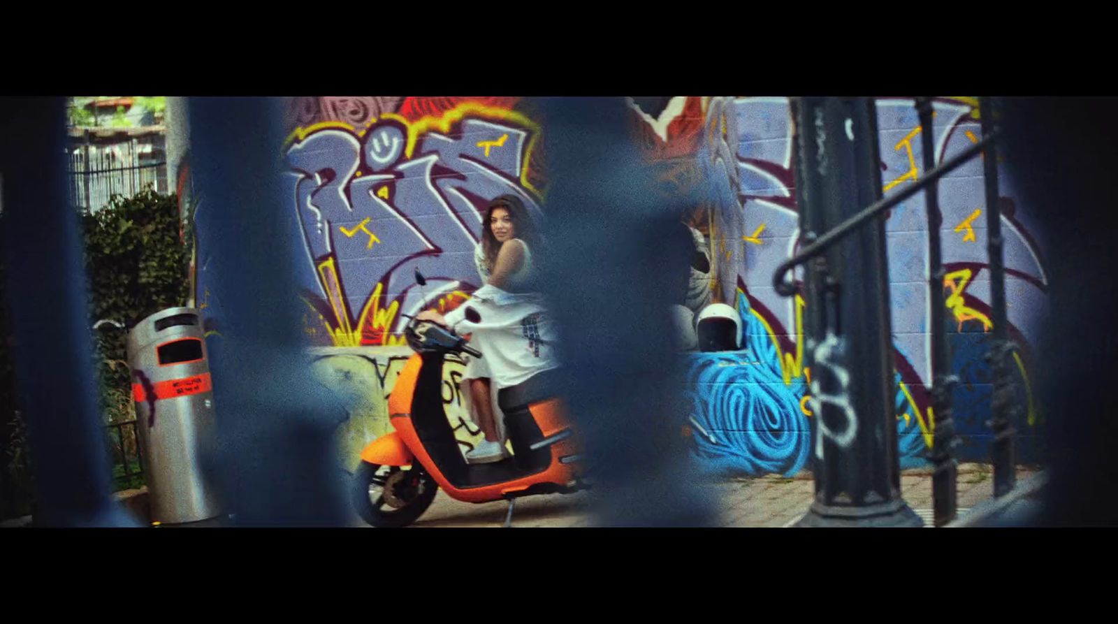 a scooter parked in front of a graffiti covered wall