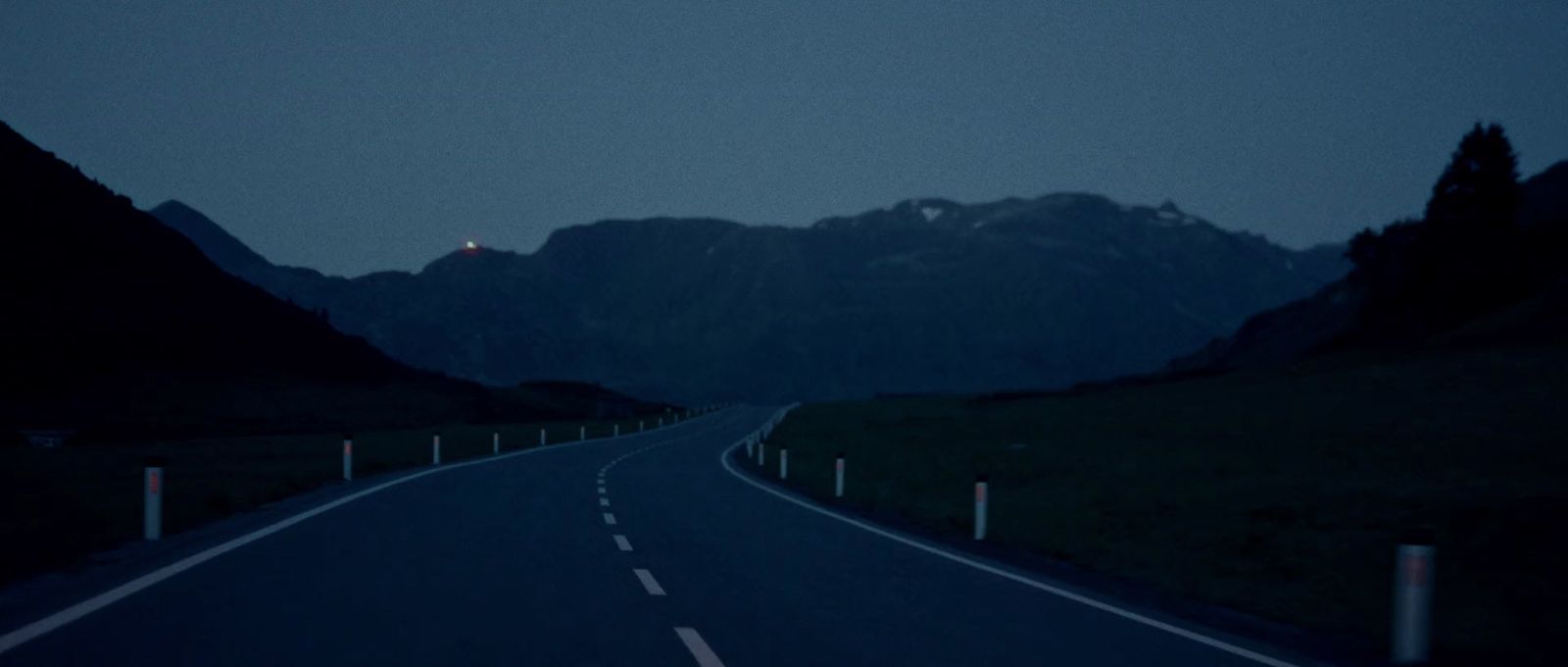 an empty road with mountains in the background