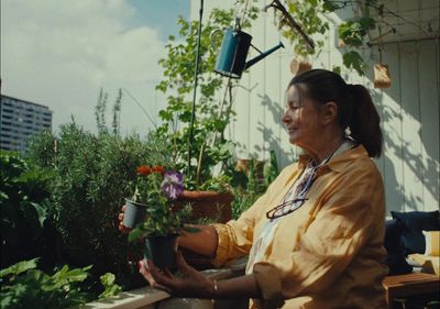 a woman holding a potted plant on a balcony