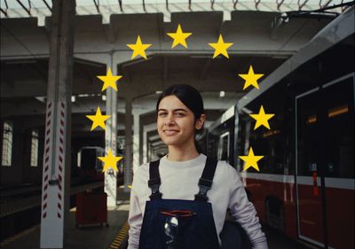 a woman standing in front of a train with yellow stars on it