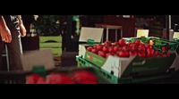 a man standing next to a box of apples