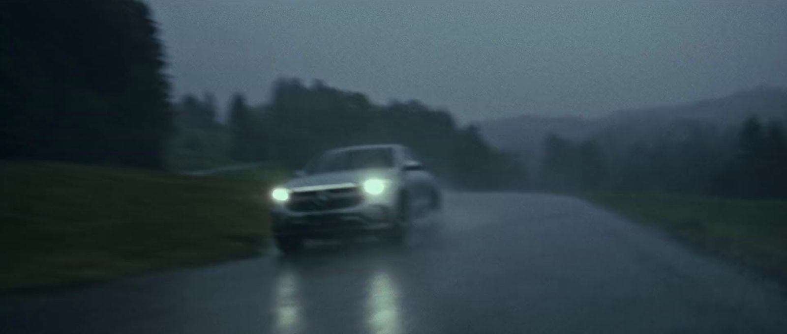 a car driving down a road in the rain