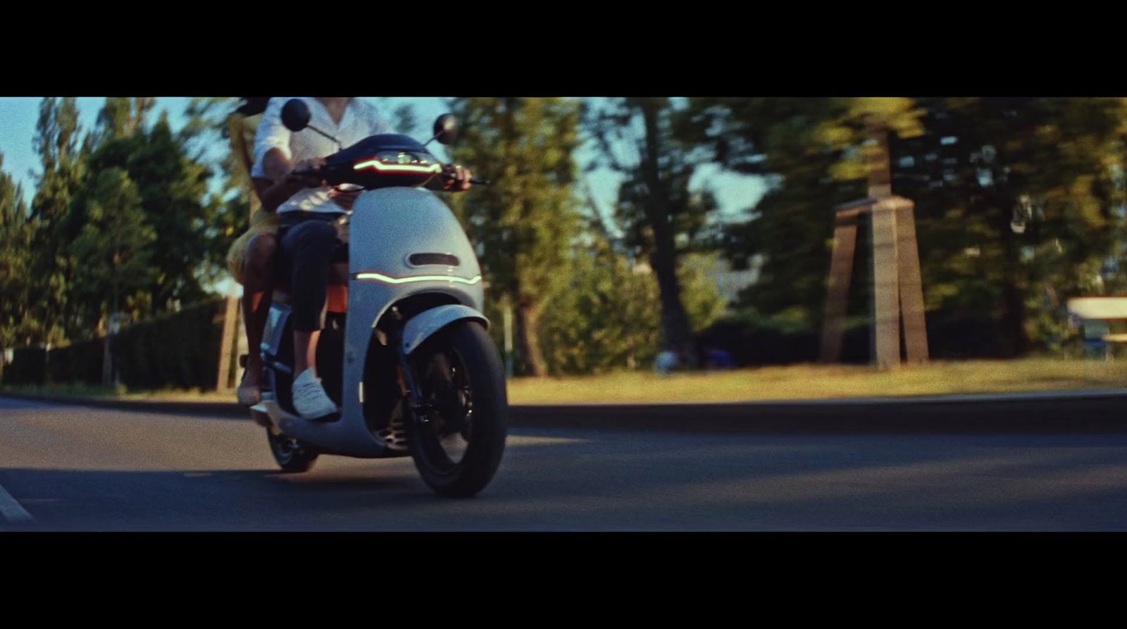 a man riding on the back of a motorcycle down a street