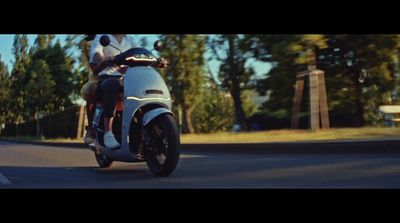 a man riding on the back of a motorcycle down a street