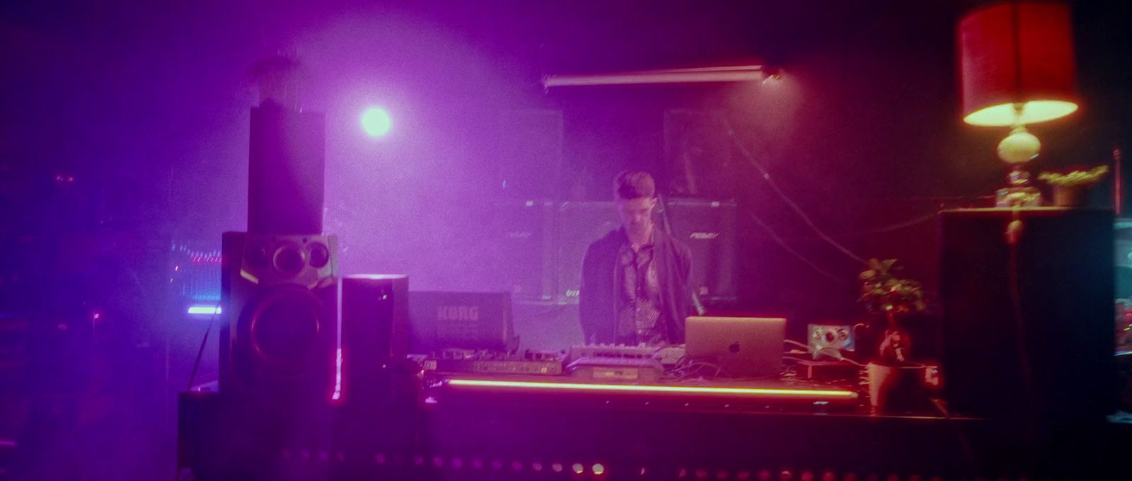 a dj mixing in front of a purple light