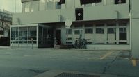 an empty parking lot with a building in the background