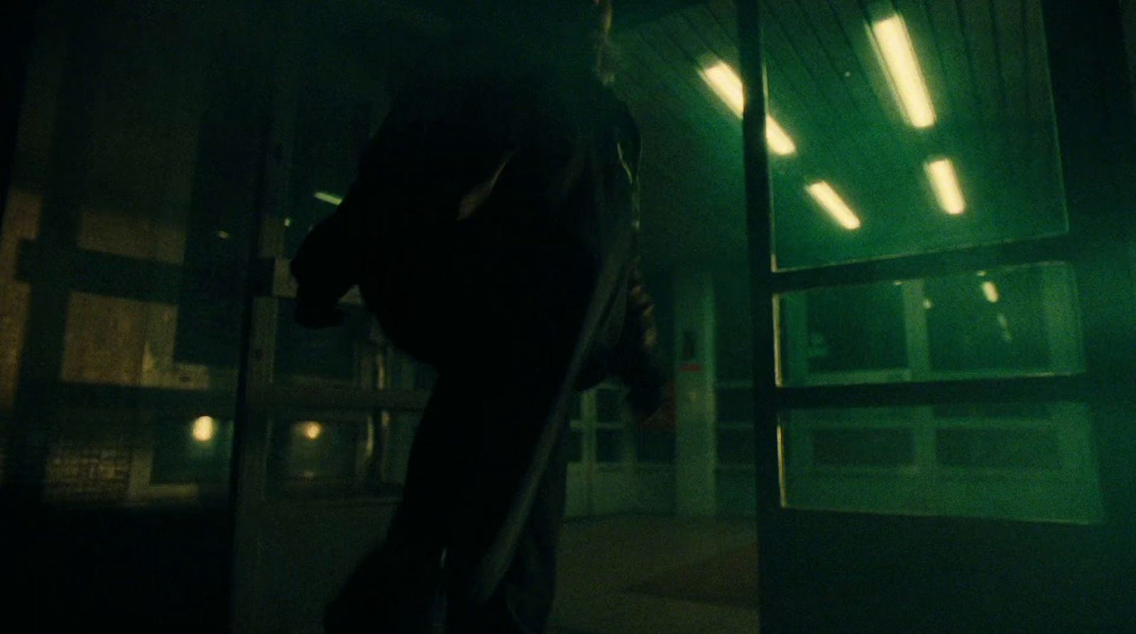 a man walking out of a building at night