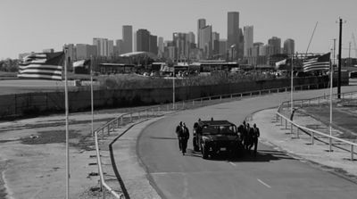 a black and white photo of an old car driving down a road