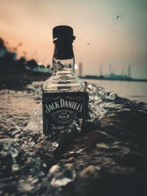 a bottle of jack daniels sitting in the water