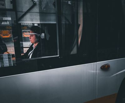 a man sitting in a bus looking out the window