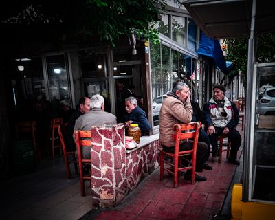 a group of people sitting at a table outside of a restaurant
