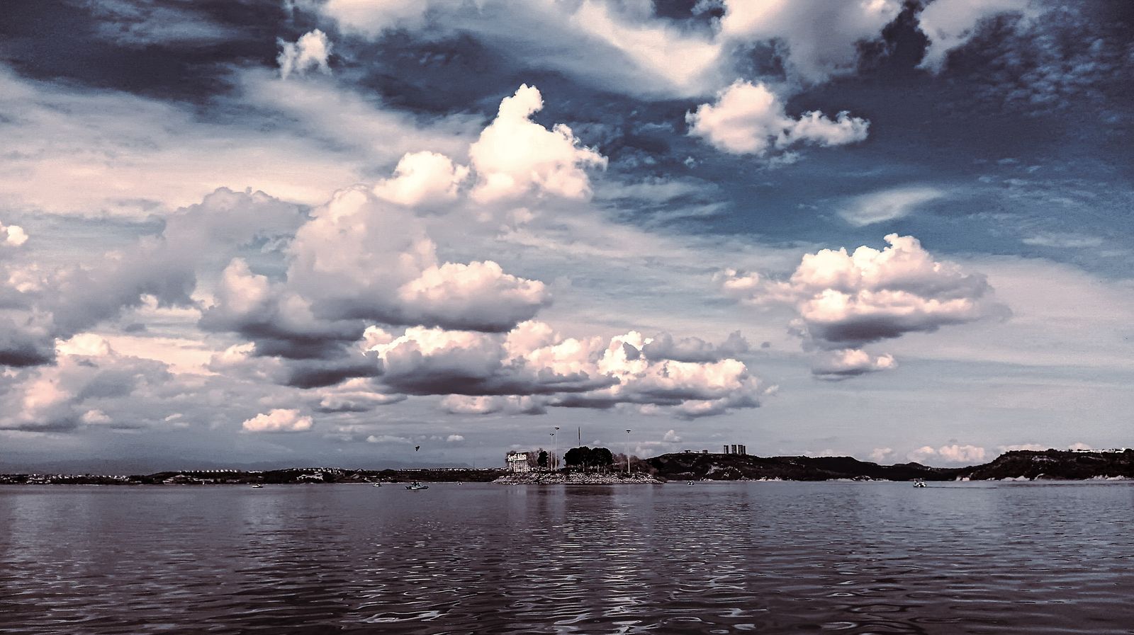 a large body of water under a cloudy sky