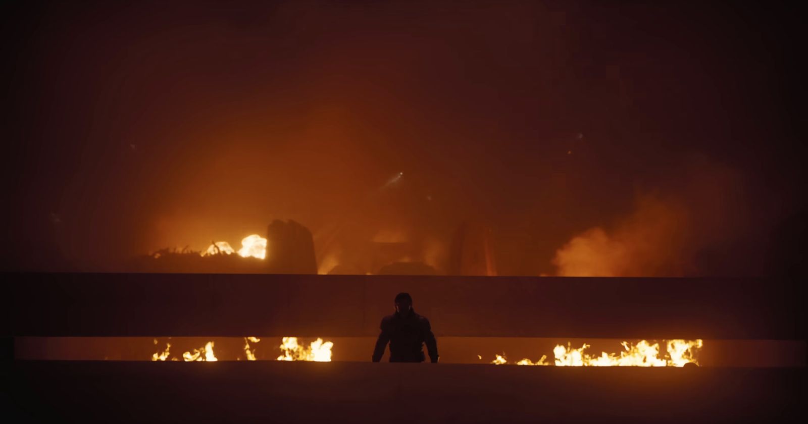 a man standing in front of a fire