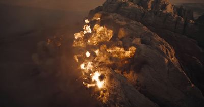 an aerial view of a mountain with a lot of smoke coming out of it