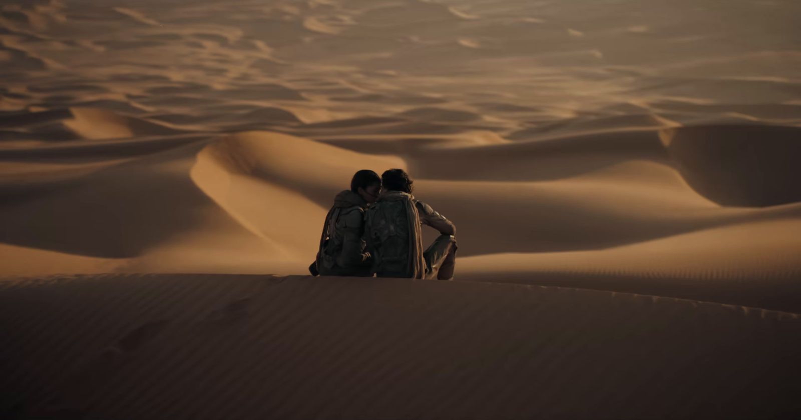 two people standing in the middle of a desert