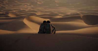 two people standing in the middle of a desert