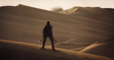 a woman standing in the middle of a desert