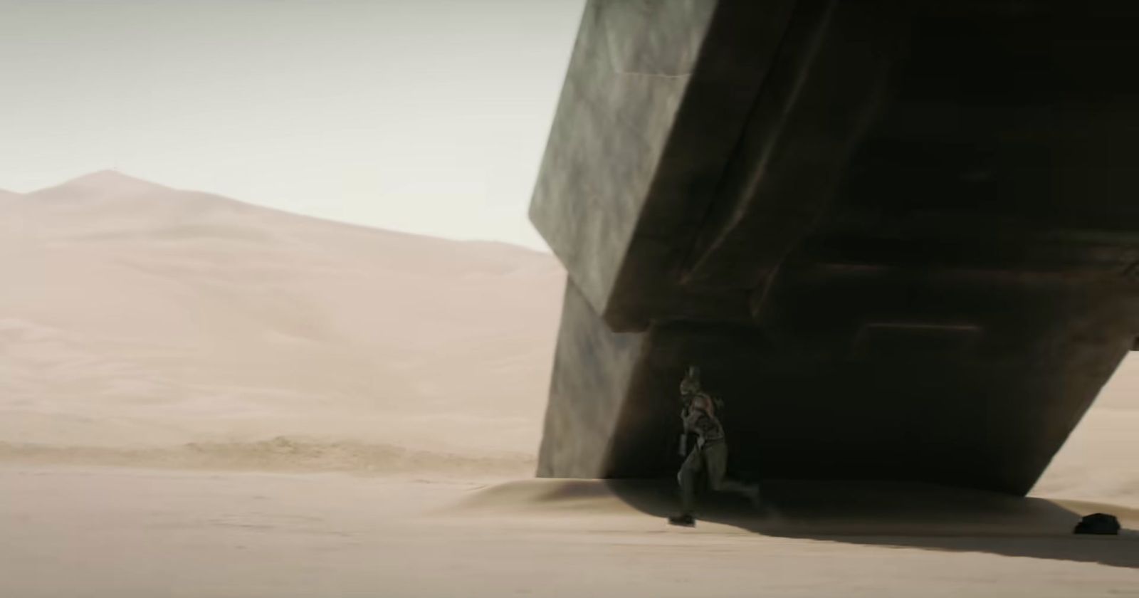 a man standing in front of a large structure in the desert