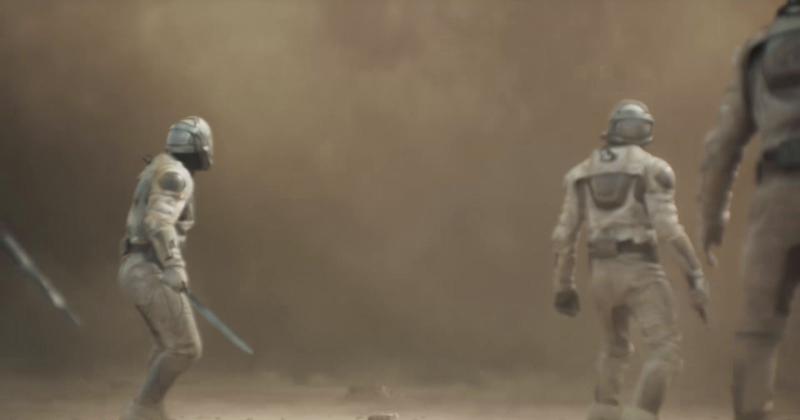 a group of people in space suits standing in the dirt