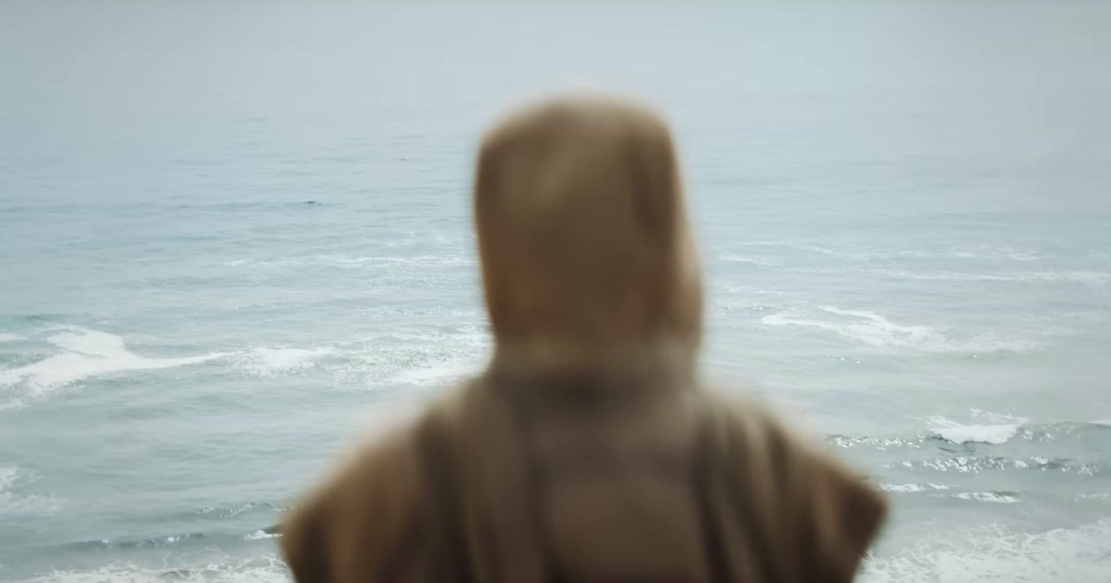 a blurry photo of a person standing in front of a body of water