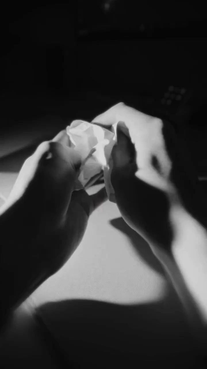 a black and white photo of a person's hands holding a piece of paper