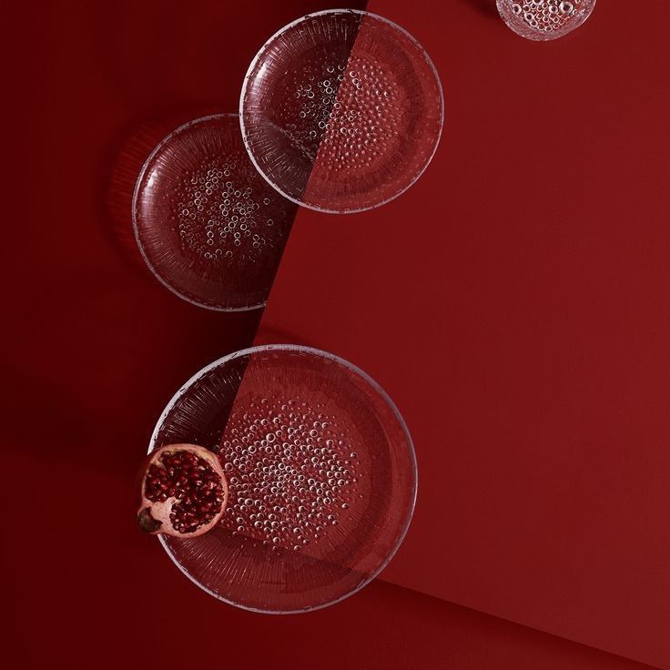 two glasses of wine with a half of a grapefruit on a red background