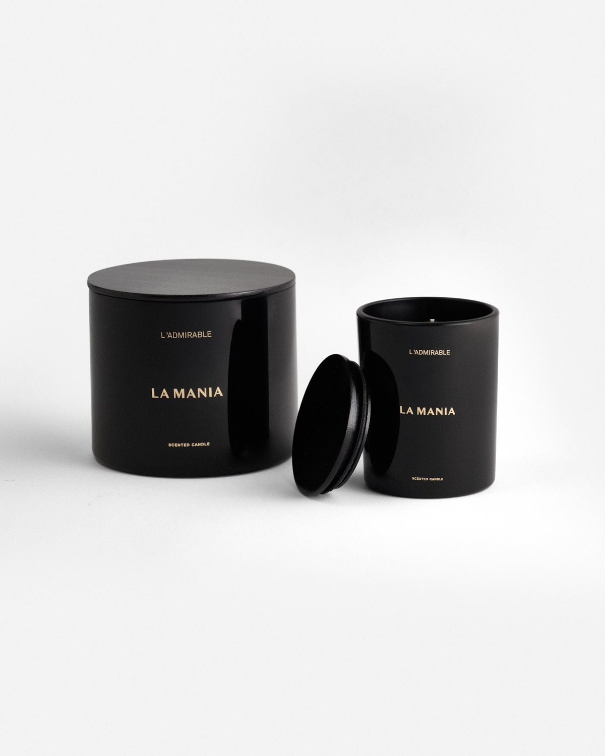 a black candle with a black lid and a white background