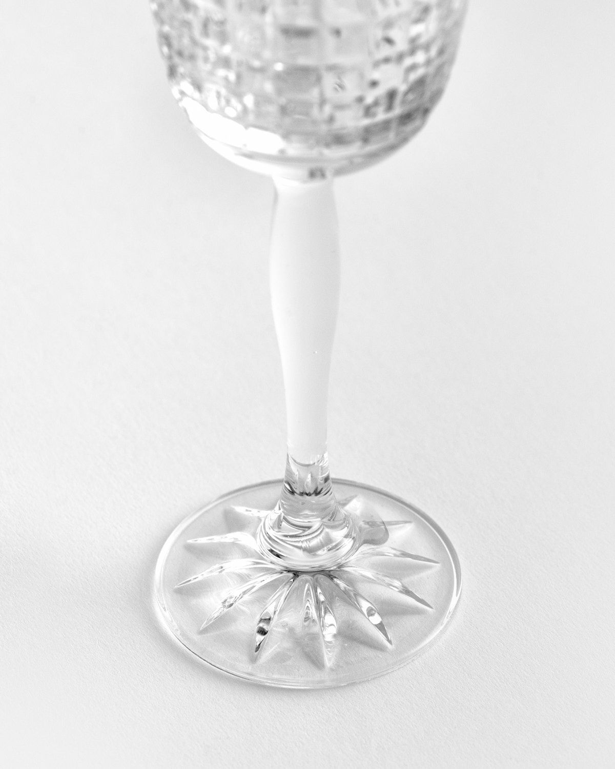 a wine glass sitting on a white surface