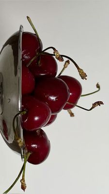 a bunch of cherries in a glass vase