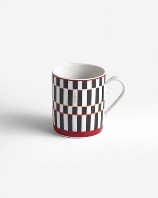 a black and white coffee cup with a red stripe