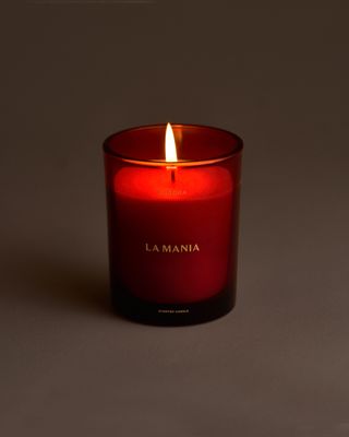 a red candle is lit on a gray surface
