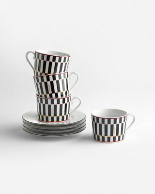 a stack of black and white cups and saucers