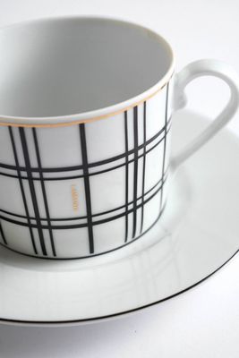 a white and black cup and saucer on a plate
