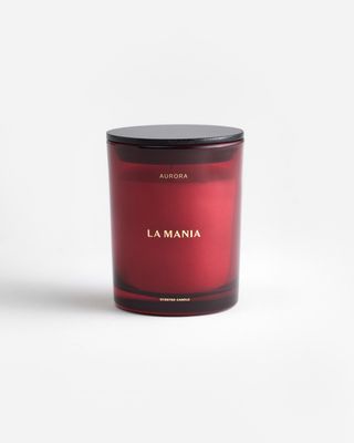 a red candle with a black lid on a white background