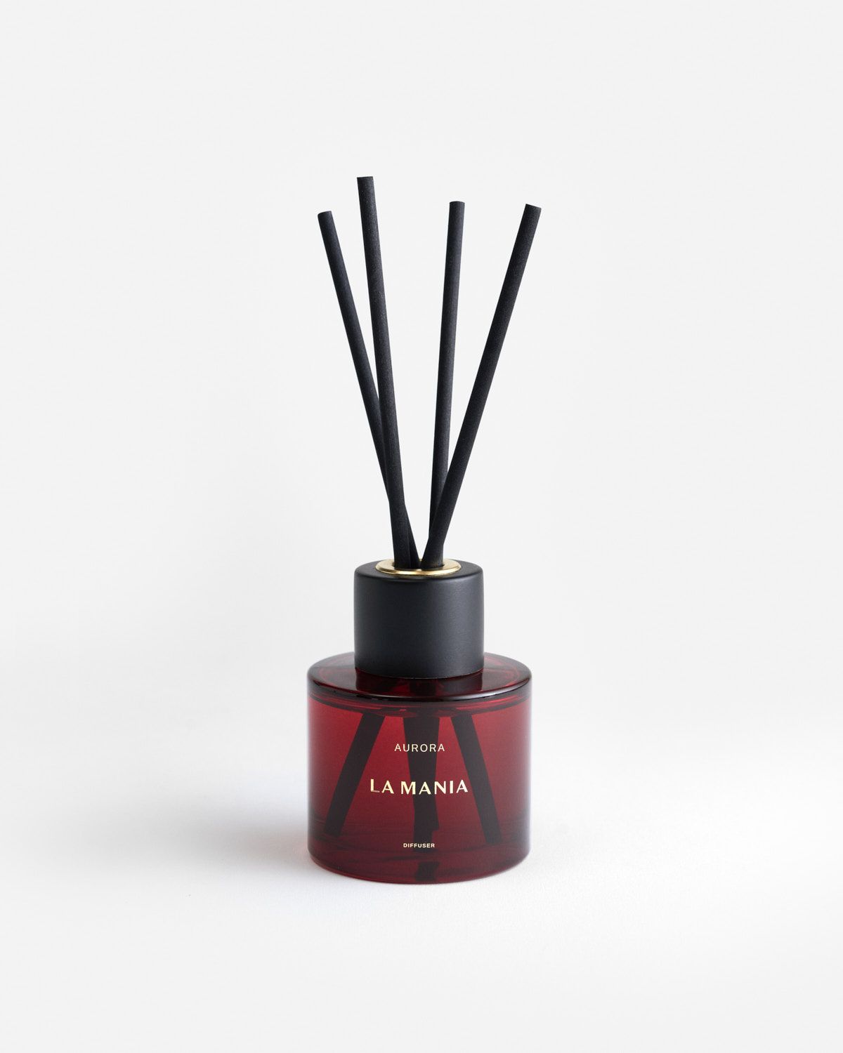 a red bottle with black sticks in it